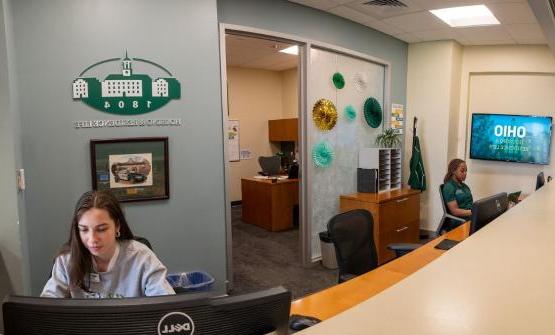 photo of student staff working the housing and residence life front desk